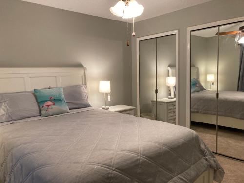 a bedroom with a large bed and a mirror at Flamingo Heated Pool House in Palm Coast