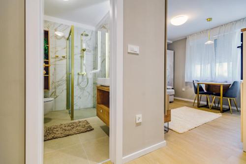 a bathroom with a shower and a sink and a table at Stylish apartments - near Zadar bridge in Zadar