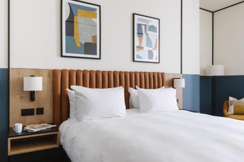 a bedroom with a large bed with white pillows at voco Belfast by IHG in Belfast