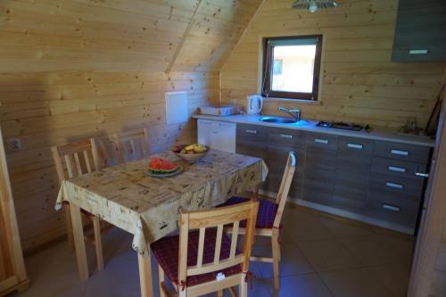 a kitchen with a table and chairs in a cabin at Domki nad Soliną - Bieszczadzka Osada 512-823-385 in Solina