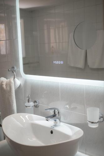 a bathroom with a white sink and a mirror at Filoxenia DD in Agios Rokkos