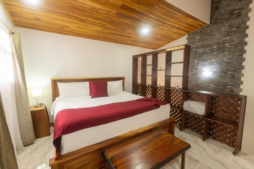 a bedroom with a large bed with a wooden headboard at Casas Clusia in Monteverde Costa Rica