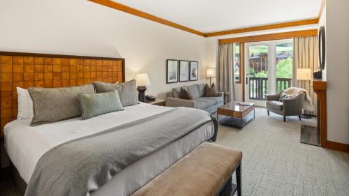 a bedroom with a large bed and a living room at 1332 Lodge At Spruce Peak Ski in Ski Out King Studio By Stowe Mountain Rentals in Stowe