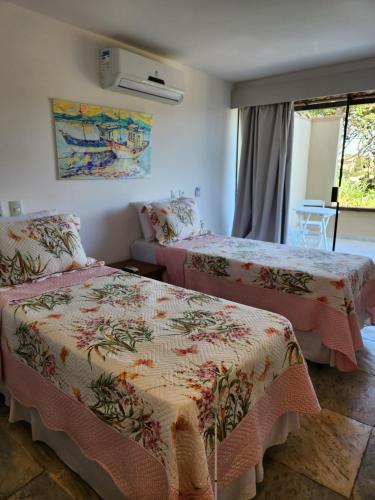 a bedroom with two beds and a window at Pousada Dreamland Buzios in Búzios