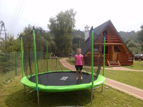 a young girl standing on a trampoline at Domki nad Soliną - Bieszczadzka Osada 512-823-385 in Solina