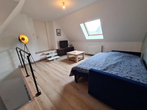 une chambre avec un lit, une télévision et une fenêtre dans l'établissement Chez Laura et Jean-Marc, à Angres