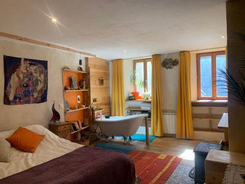 - une chambre avec une baignoire, un lit et une salle de bains dans l'établissement Appartement 110m2 chaleureux et familial, à Briançon