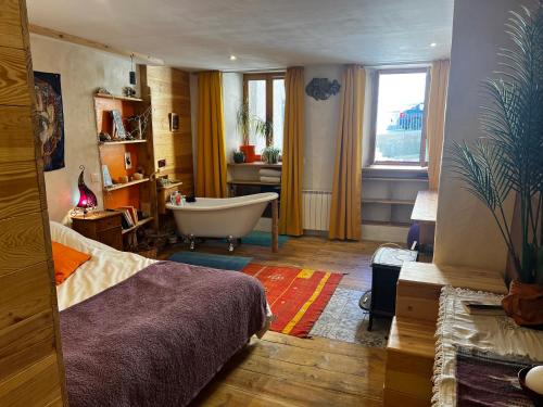 - une chambre avec un lit, une baignoire et une salle de bains dans l'établissement Appartement 110m2 chaleureux et familial, à Briançon