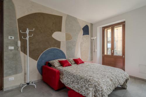 a bedroom with a bed with red pillows on it at Ca'Maira Dronero in Dronero
