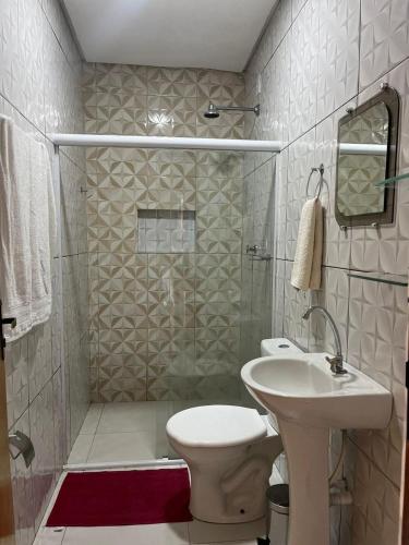 a bathroom with a toilet and a sink and a shower at Casa De Temporada Lapinha in Piranhas