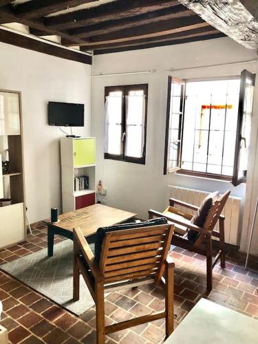 Cette chambre dispose d'une table, de deux bancs et d'une télévision. dans l'établissement Studio cœur de ville, à Auxerre