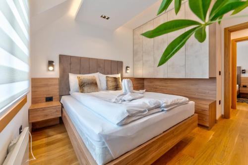 ein Schlafzimmer mit einem großen Bett mit einem hölzernen Kopfteil in der Unterkunft Pino Silvestre SPA 19 in Zlatibor