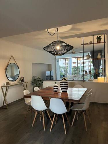 a dining room with a wooden table and white chairs at Condominio Marina Vallarta in Puerto Vallarta