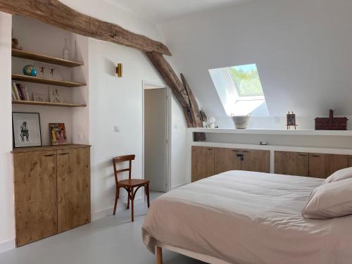 une chambre avec un lit, une chaise et une fenêtre dans l'établissement Le Meix Saint Vital, à Barizey