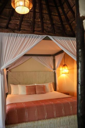 a bedroom with a bed with a canopy at Alquimia Hotel Boutique in Tulum
