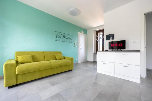 a living room with a yellow couch and a tv at Ca'Maira Dronero in Dronero