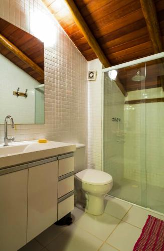 a bathroom with a toilet and a sink and a shower at Maresias Beach House - Casas de alugueis em cond beira mar in Maresias