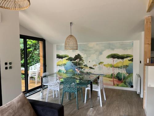 une salle à manger avec une table et des chaises en verre dans l'établissement Villa Marylka - une cabane au Pyla, à La Teste-de-Buch