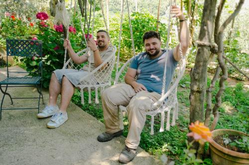 two men sitting in rocking chairs in a garden at Rosa e Valentino in Ravello