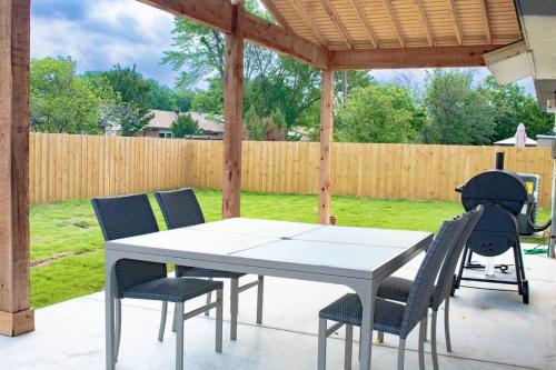 a ping pong table and chairs on a patio at Feel at Home! New Renovated House By Grandscapes in The Colony