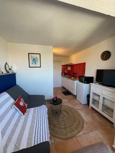 ein Wohnzimmer mit Couch und Küche in der Unterkunft Capstay studio Barcarès in Le Barcarès
