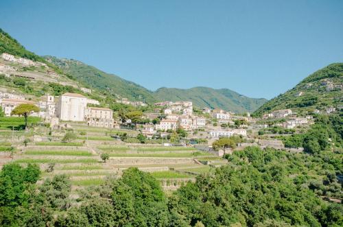a village on a hill with trees and houses at Rosa e Valentino in Ravello