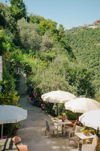 a row of tables with umbrellas in a garden at Rosa e Valentino in Ravello