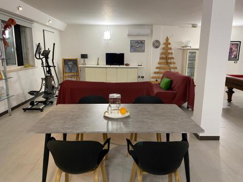 a living room with a table and a living room with a couch at Alloggio turistico Villa Camelia Lavinio in Anzio