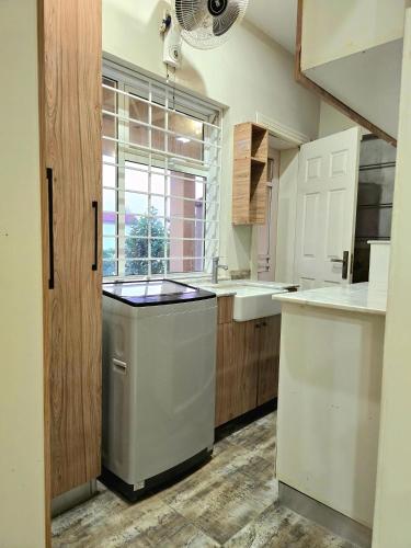 a kitchen with white cabinets and a sink and a window at Stylish Independent 3-Bedroom House in Bahria Town in Rawalpindi