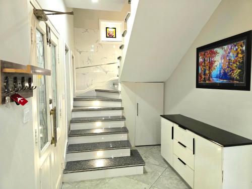 a staircase in a home with white walls and white stairs at Stylish Independent 3-Bedroom House in Bahria Town in Rawalpindi