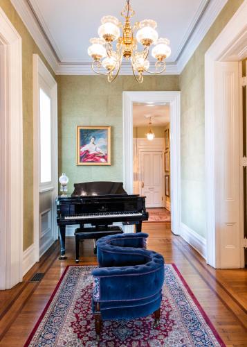 a living room with a piano and a rug at DuPont Mansion Bed & Breakfast in Louisville