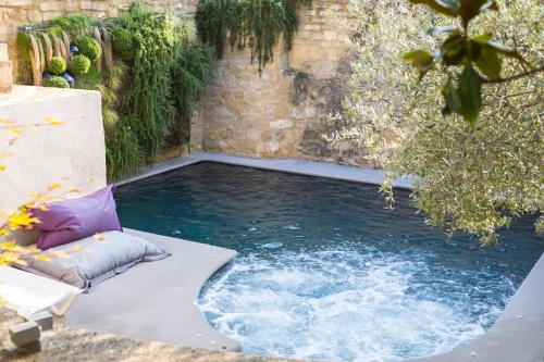 a pool of water in a backyard with a patio at Le Castellas Hotel & SPA - TERITORIA in Collias