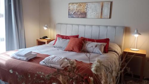 a bedroom with a bed with two towels on it at De Los Andes Hotel Boutique in Ciudad Lujan de Cuyo
