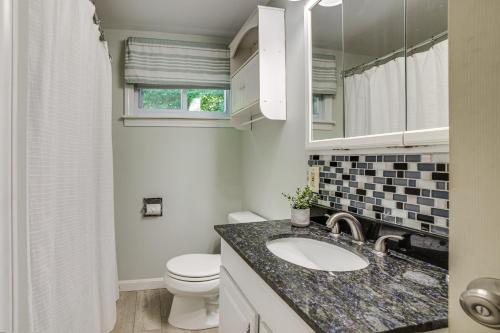 une salle de bain avec un lavabo, des toilettes et un miroir dans l'établissement Breathtaking Newbury Cottage with Deck on Chalk Pond, à Newbury