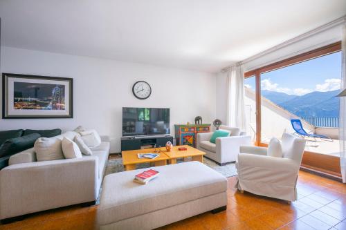 een woonkamer met witte meubels en een groot raam bij Bella Menaggio Terrazzo in Menaggio