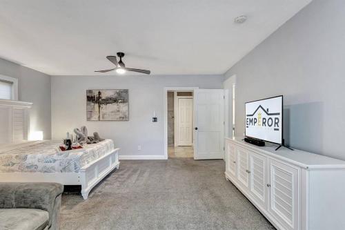 a bedroom with a bed and a tv in it at Stunning Lake House with Heated Pool & Ping Pong! in Lutz