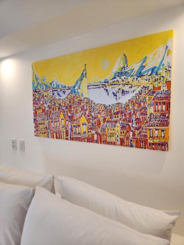a painting hanging on a wall above a white couch at Pousada Dreamland Buzios in Búzios