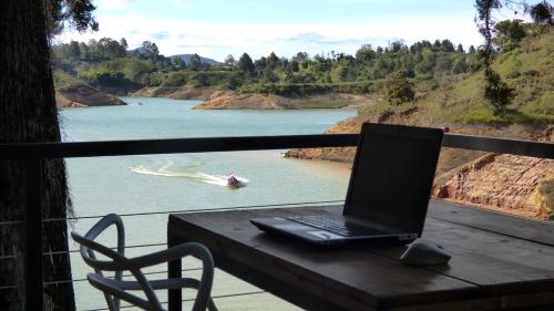 a laptop computer sitting on a table next to a river at Tree House, Cabaña privada con Jacuzzi in Guatapé