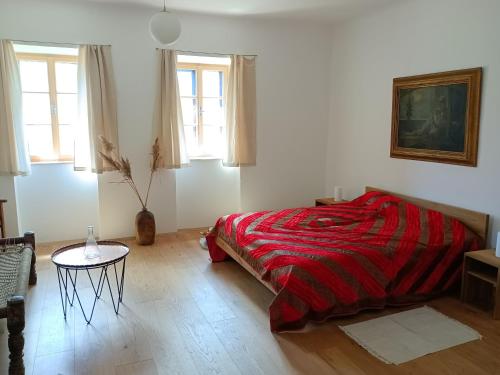 a bedroom with a bed and a table and windows at Ferienhaus Himmelreich in Kaisersdorf