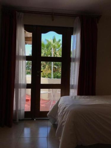 a bedroom with a bed and a glass door at De Los Andes Hotel Boutique in Ciudad Lujan de Cuyo
