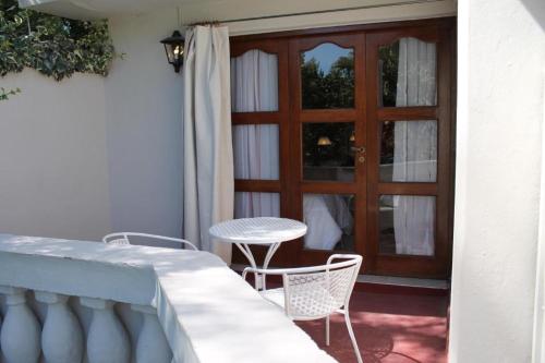 a patio with a table and chairs and a door at De Los Andes Hotel Boutique in Ciudad Lujan de Cuyo