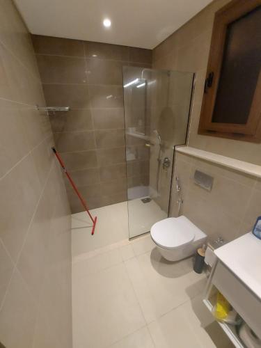 a bathroom with a toilet and a glass shower at Modern reviera in Salalah