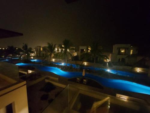 a view of a swimming pool at night at Modern reviera in Salalah