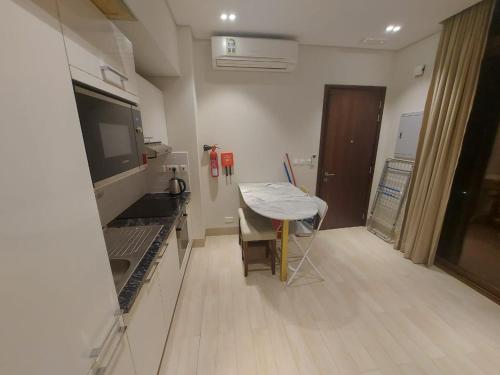 a kitchen with a table and a small table in a room at Modern reviera in Salalah