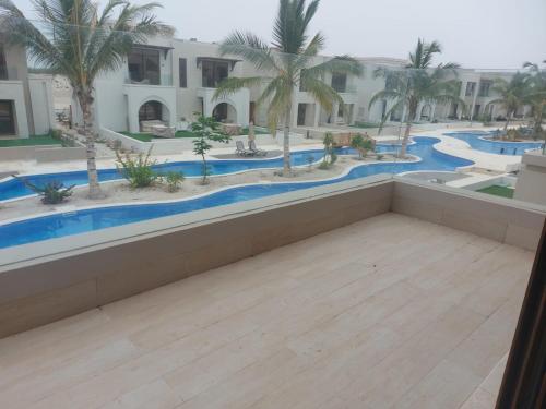 a view of a pool from the balcony of a resort at Modern reviera in Salalah