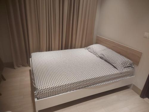 a small bed in a bedroom with curtains at Modern reviera in Salalah
