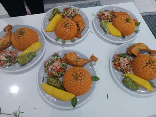 a white table topped with plates of fruit and vegetables at Maison des Oliviers, Yasmine Hammamet, Bouficha in Hammamet Sud