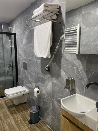 a bathroom with a toilet and a sink at Ozn Suit Airport Hotel in Arnavutköy