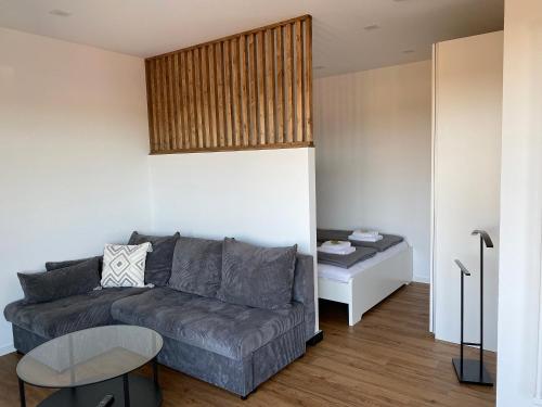 ein Wohnzimmer mit einer Couch und einem Tisch in der Unterkunft Little Penthouse in Waldbüttelbrunn