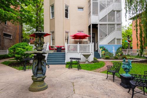a fountain in front of a building with chairs and umbrellas at DuPont Mansion Bed & Breakfast in Louisville